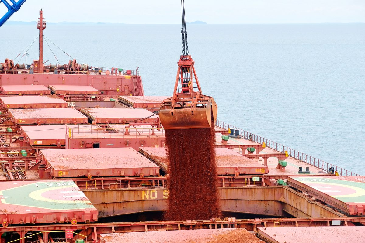 Open pit bauxite mine with red ore and excavation equipment